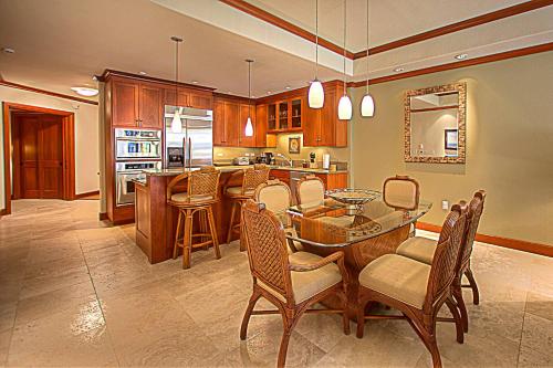a large kitchen with a table and chairs and a counter at Kolea 11D - Walk to the Beach in Waikoloa