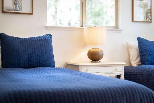 a bedroom with two blue beds and a lamp on a table at Rustic Haven - Hot tub & Pet friendly in South Lake Tahoe