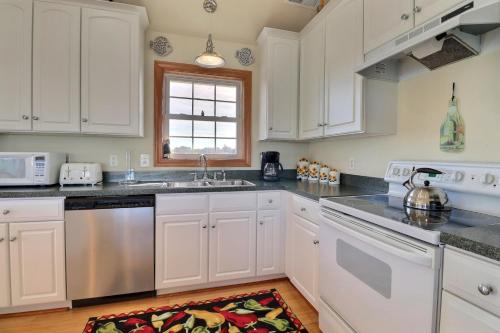 a kitchen with white cabinets and a sink at 4124 - Sound Side Out in Kitty Hawk