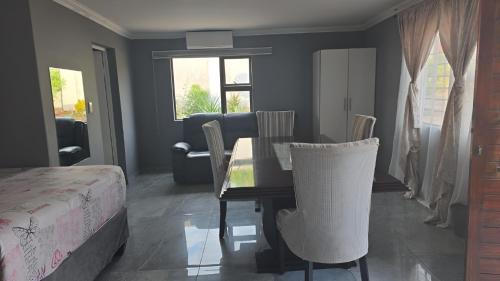 a bedroom with a dining room table and chairs at U And I GuestHouse in Empangeni