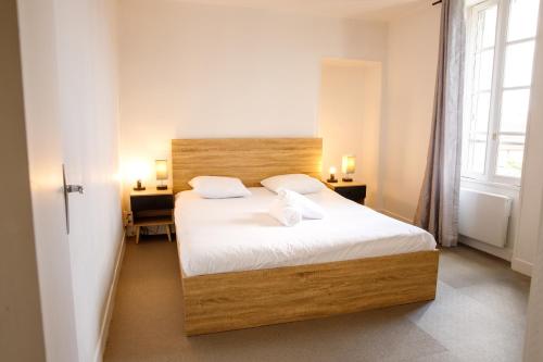 a bedroom with a bed with two pillows on it at La Place Servant 2 in Montluçon