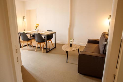 a living room with a table and chairs and a couch at La Place Servant 2 in Montluçon