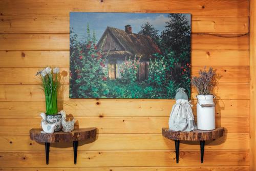 a painting of a house on a wall with two tables at Willa pod Jemiołą in Wisła