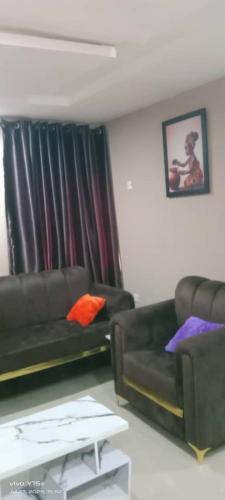 a living room with a couch and a chair at Service apartment in Ibadan