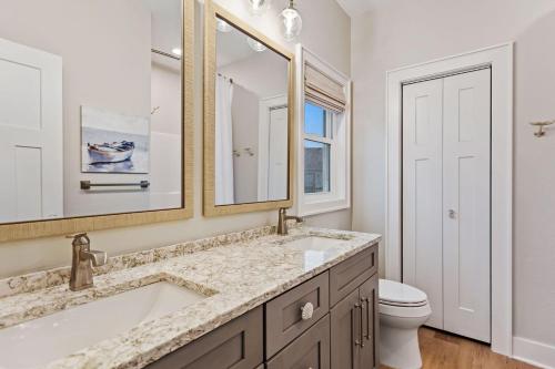 a bathroom with a sink and a toilet and a mirror at 5046 - Pelican Palm in Kill Devil Hills