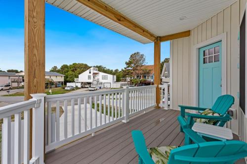 a porch with two chairs and a blue door at 5046 - Pelican Palm in Kill Devil Hills