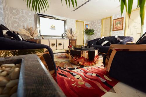 a living room with couches and a television on the wall at Number One Oxford Street Hotel & Suites in Accra