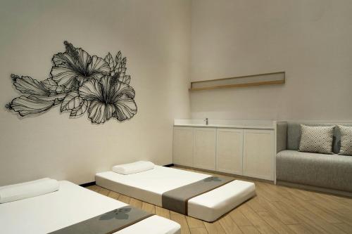 a living room with two beds and a couch at Courtyard by Marriott Bangkok Suvarnabhumi Airport in Lat Krabang