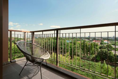 a chair on a balcony with a view at Courtyard by Marriott Bangkok Suvarnabhumi Airport in Lat Krabang