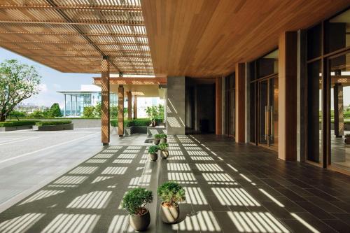 a hallway with potted plants on a building at Courtyard by Marriott Bangkok Suvarnabhumi Airport in Lat Krabang