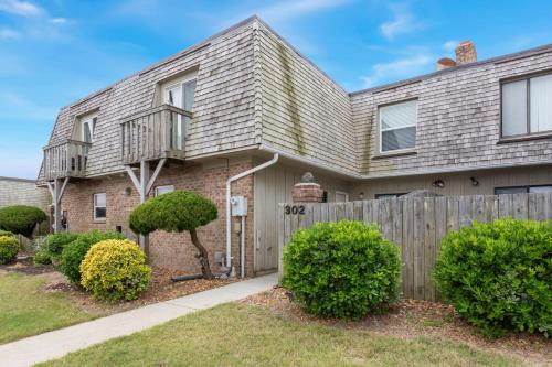 a house with a wooden fence and bushes at SC302 - Kitty Hawk Flyer in Kitty Hawk