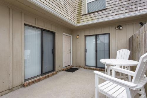 a patio with two white chairs and a table at SC302 - Kitty Hawk Flyer in Kitty Hawk