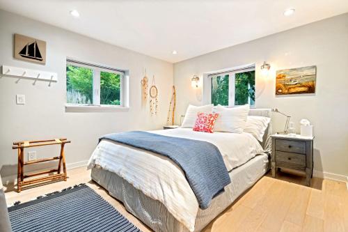 a bedroom with a large bed and two windows at Kayaks & Sup's - Private Dock - Grand Piano in Kittery