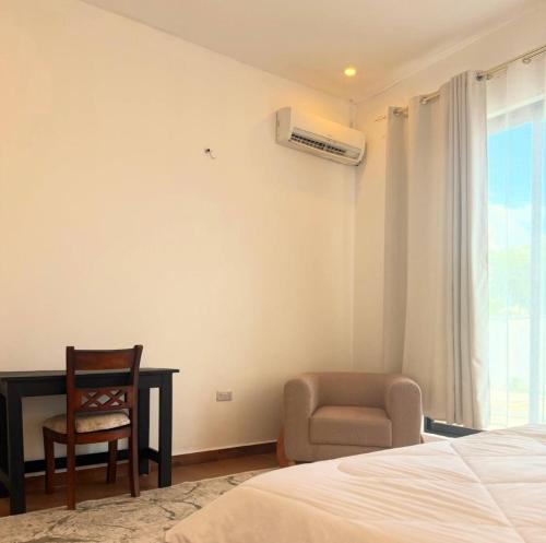 a bedroom with a bed and a desk and a chair at HS Villas in Zanzibar City