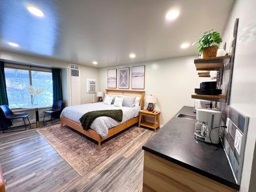 ein Schlafzimmer mit einem Bett und einem Schreibtisch mit einem Fernseher in der Unterkunft Modern Studio 65 TV, King Bed, Hot Tub in Park City