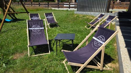 a group of lawn chairs sitting in the grass at Apartamenty TAFLA nad Jeziorem Czorsztyńskim in Kluszkowce