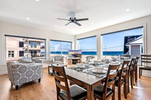 a dining room with a table and chairs and large windows at Oceanfront Home Beach Access Deck & Ping Pong in Old Orchard Beach