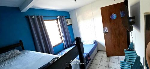 a small room with a bed and a window at Mandallah Hostel in Joinville