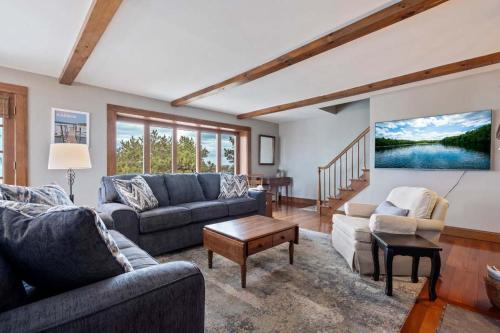 a living room with two couches and a table at Beachfront and only 30 Steps To Beach in Saco