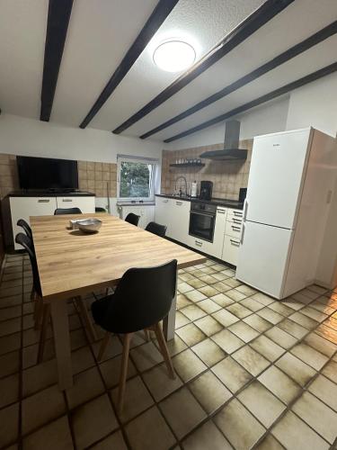 a kitchen with a wooden table and white appliances at Apartment Oberhausen in Oberhausen