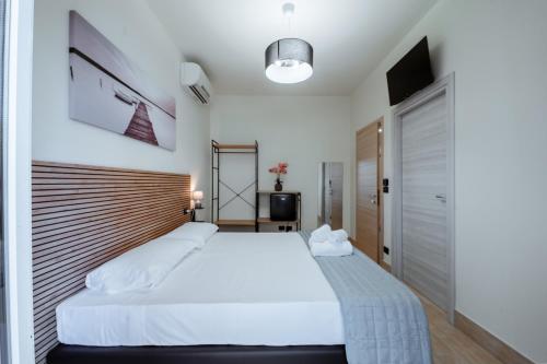 a bedroom with a large white bed with a wooden headboard at Independent Rooms in Verona