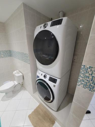 una lavadora en un baño con inodoro en Sunny Bluu Villas, en Meads Bay