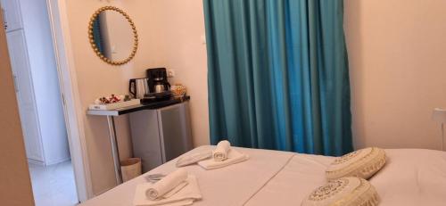 a room with a bed and a blue curtain at MANI HOLIDAYS Rooms in Neon Oitilon