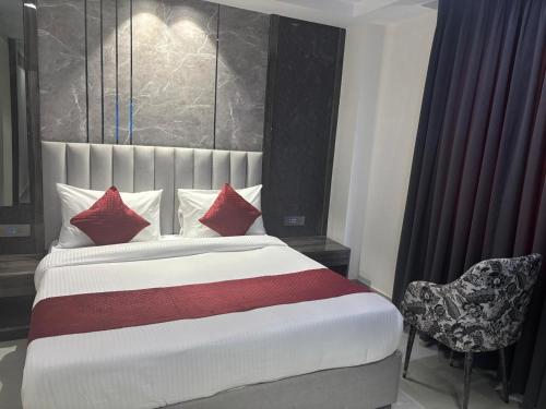 a bedroom with a bed with red pillows and a chair at Hotel Mountain Bliss' New Delhi City center in New Delhi