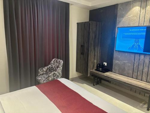 a bedroom with a bed and a tv and a chair at Hotel Mountain Bliss' New Delhi City center in New Delhi