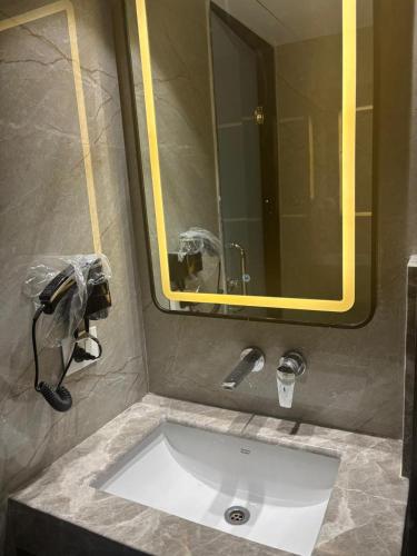 a sink in a bathroom with a large mirror at Hotel Mountain Bliss' New Delhi City center in New Delhi