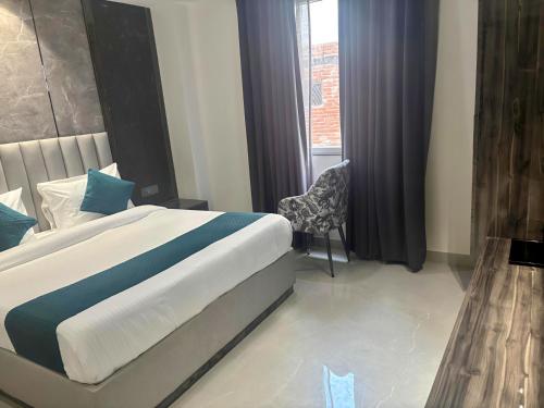 a bedroom with a bed and a chair and a window at Hotel Mountain Bliss' New Delhi City center in New Delhi