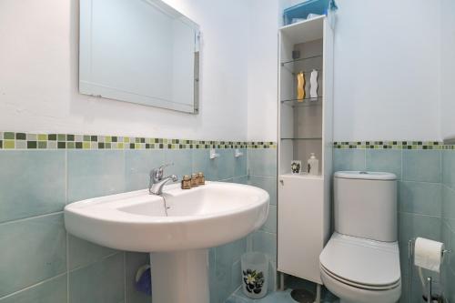 ein Badezimmer mit Waschbecken, Toilette und Spiegel in der Unterkunft Brisa del Valle Casa con Jardín Piscina Parking in Vera