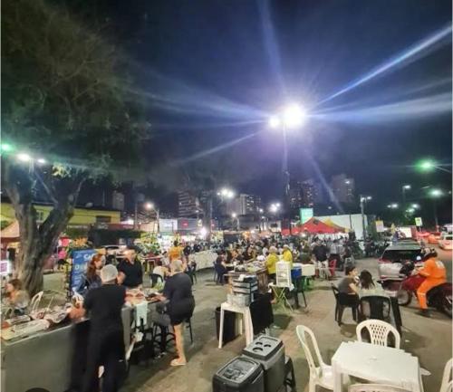 Eine Menschenmenge, die nachts an Tischen sitzt. in der Unterkunft Ellen2000 in Fortaleza