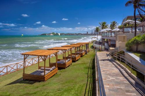 a row of beds on the beach next to the ocean at Serhs Natal Grand Hotel & Resort in Natal