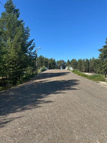 an empty road with trees on the side of it at Virpiniemen Maston Villa, Oulu in Oulu