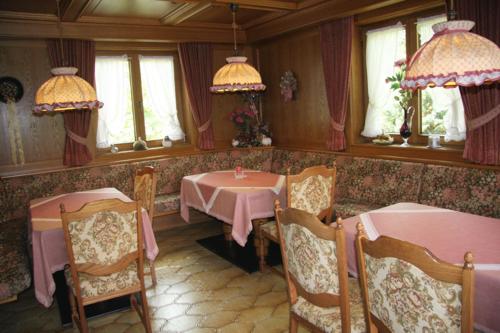 una sala da pranzo con due tavoli, sedie e finestre di Gästehaus Sylvia a Biberwier