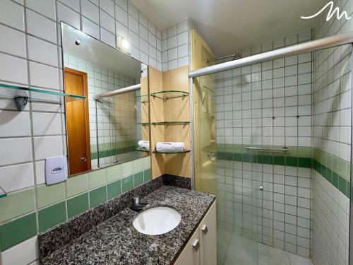 a bathroom with a sink and a mirror at Tambaú Home Service - Miramar Hospedagens in Tambaú