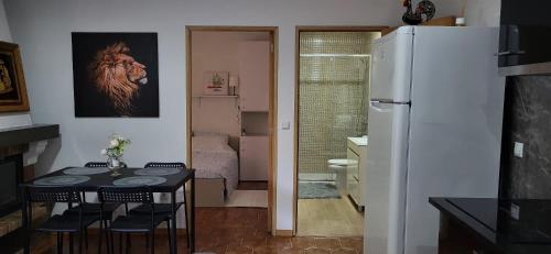 a kitchen with a table and a refrigerator at Moradia Belo horizonte in Alfena