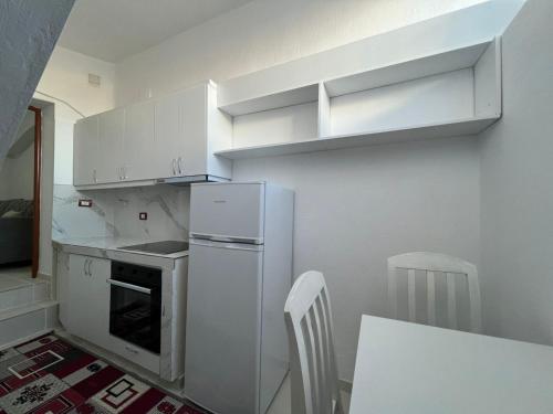 une cuisine avec un réfrigérateur blanc et une table dans l'établissement Minga Apartments, à Pogradec