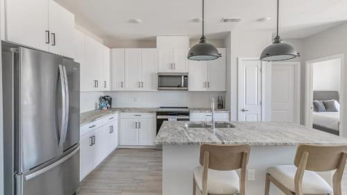 a kitchen with white cabinets and a granite counter top at Landing Apartments Dry Creek - Huntsville in Huntsville