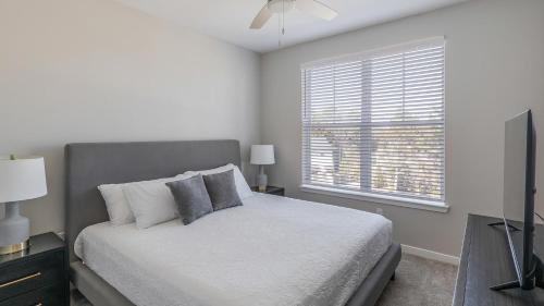 a white bedroom with a bed and a window at Landing Apartments Dry Creek - Huntsville in Huntsville