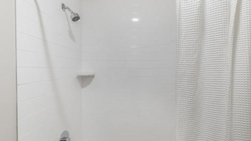 a shower with a shower curtain next to a shower at Landing Apartments Dry Creek - Huntsville in Huntsville