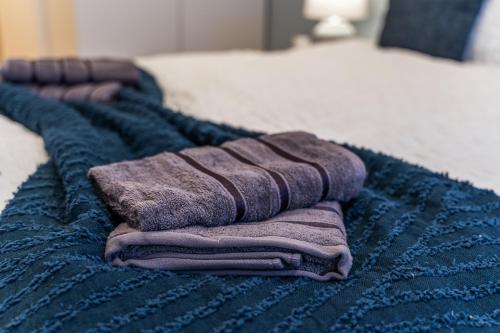 a pile of towels sitting on top of a bed at Leeds Elegant Central Flat - Sleeps 8 - View City Centre in Central Station
