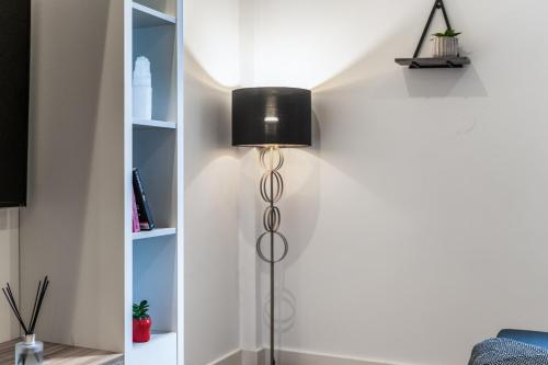 a floor lamp next to a wall with shelves at Leeds Elegant Central Flat - Sleeps 8 - View City Centre in Central Station