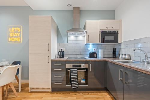 a kitchen with a stove top oven next to a sink at Leeds Elegant Central Flat - Sleeps 8 - View City Centre in Central Station