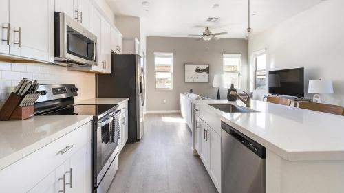 a kitchen with white cabinets and a sink and a stove at Landing at Linda Vista - Oro Valley in Oro Valley