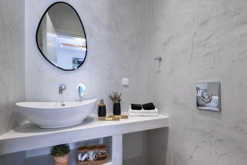 a bathroom with a white sink and a mirror at Aphrodite's Refuge in Galissas