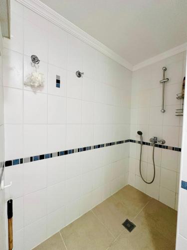a bathroom with a shower with white tiled walls at olumpus Apartman Kalkan in Kaş
