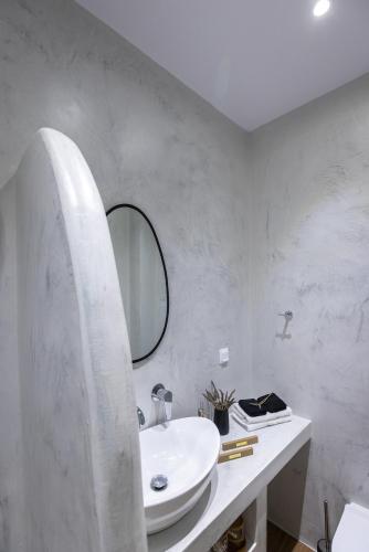 a white bathroom with a sink and a mirror at Aphrodite's Refuge in Galissas
