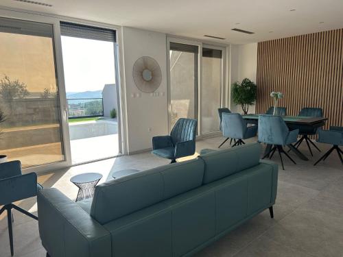 Una sala de estar con un sofá, una mesa y sillas. en Villa Solina, en Maslenica